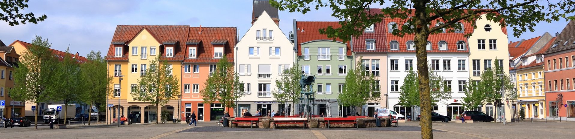 Historische Wohn- und Geschäftshäuser mit farbigen Fassaden an einem städtischen Platz